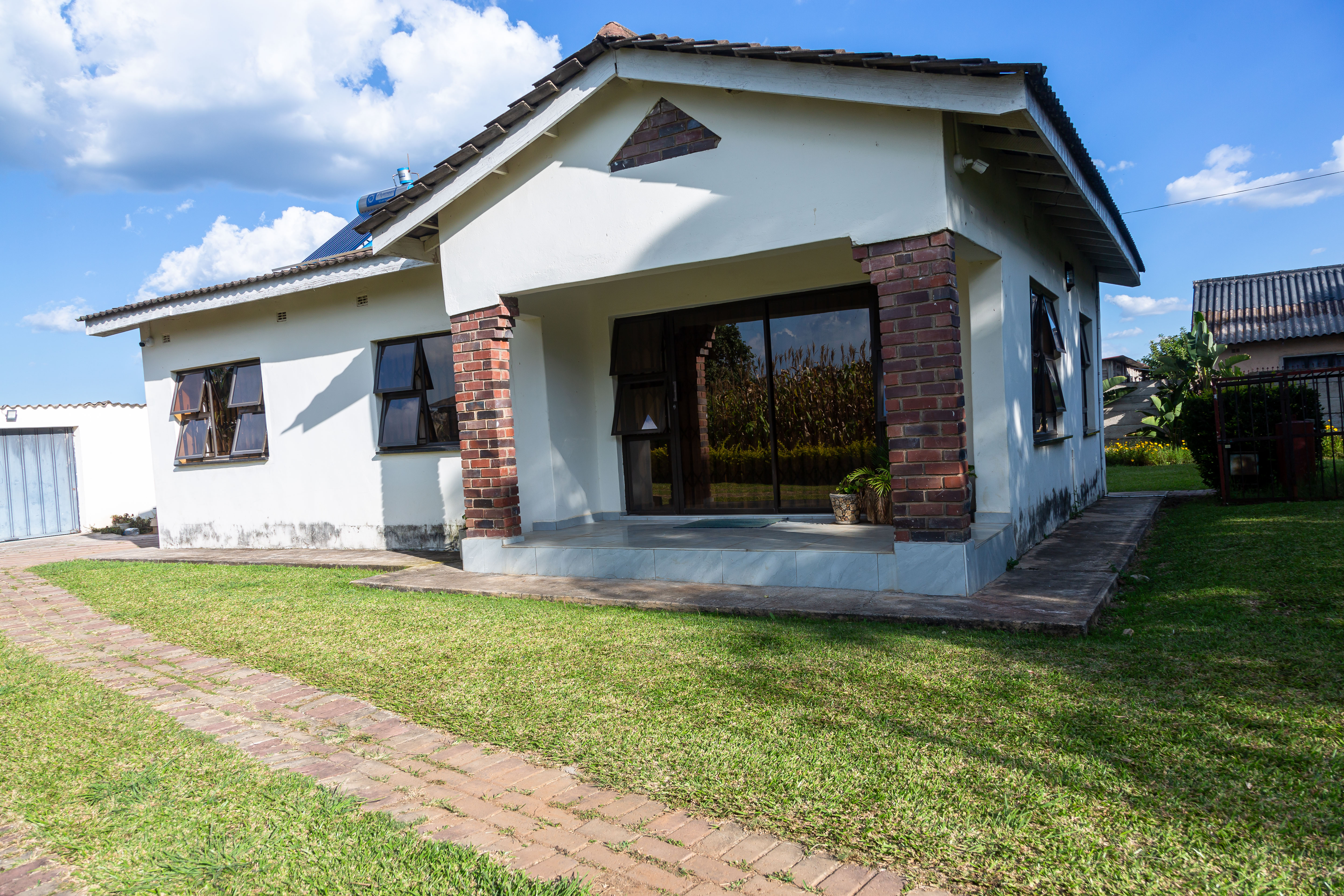 House entrance with brick columns and a lawn